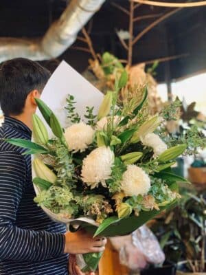 Man Holding A Bouquet of White Flowers