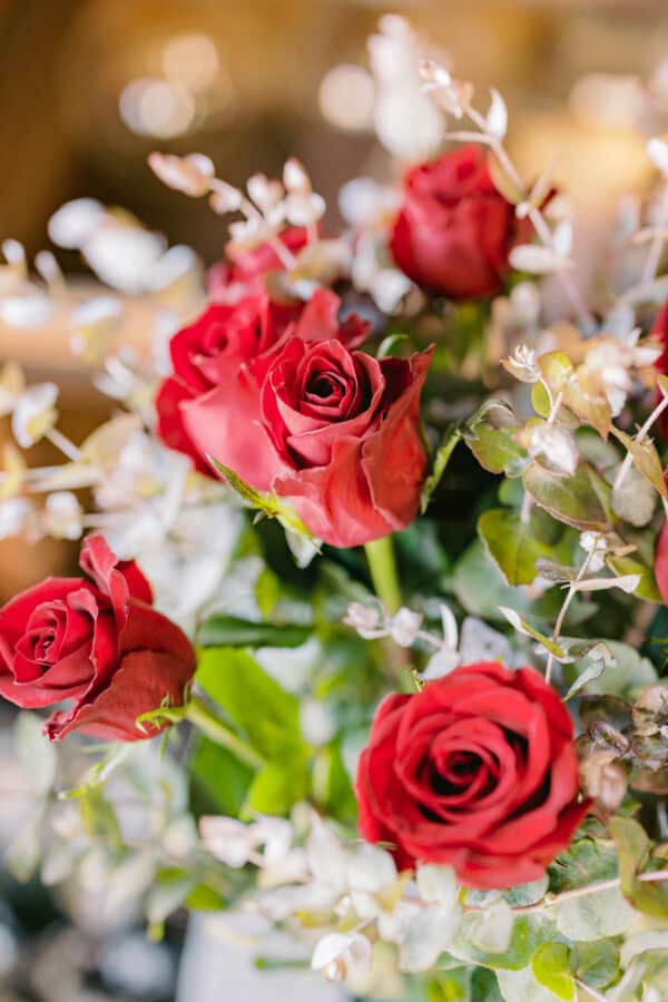Close Up Photo of A Bouquet of 12 Red Roses with Greenery